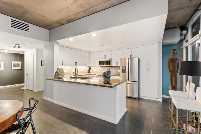 a kitchen with stainless steel appliances granite countertop a sink stove and refrigerator