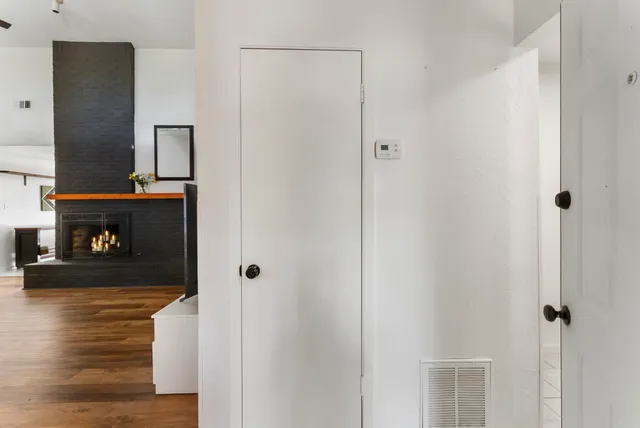 a view of a livingroom with wooden floor and a fireplace