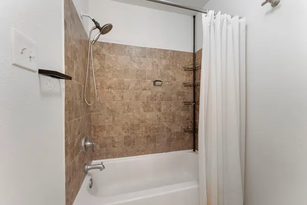 a bathroom with a shower and a bath tub