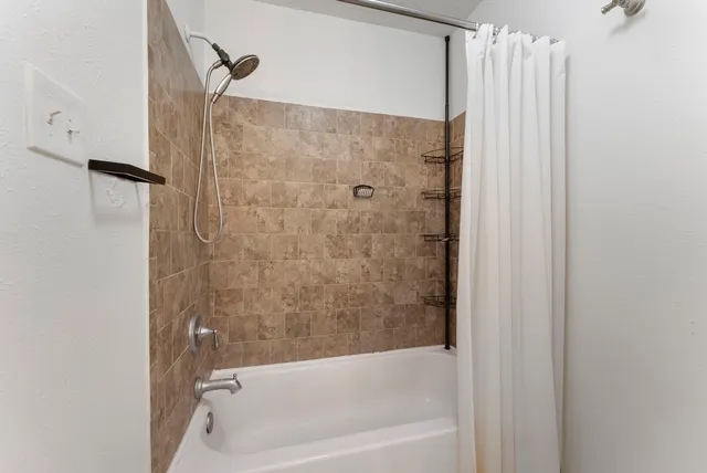 a bathroom with a shower and a bath tub