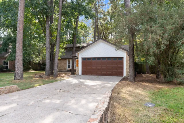 a front view of a house with a garden and trees