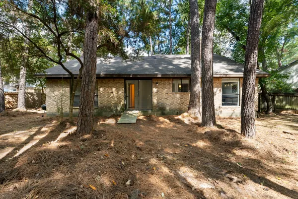 a front view of a house with a tree in front