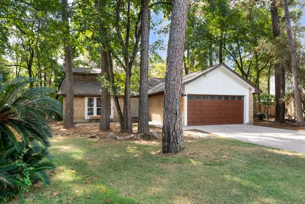 a front view of a house with a yard and tree