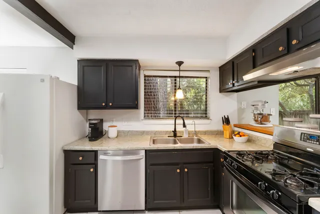 a kitchen with stainless steel appliances a sink stove and cabinets