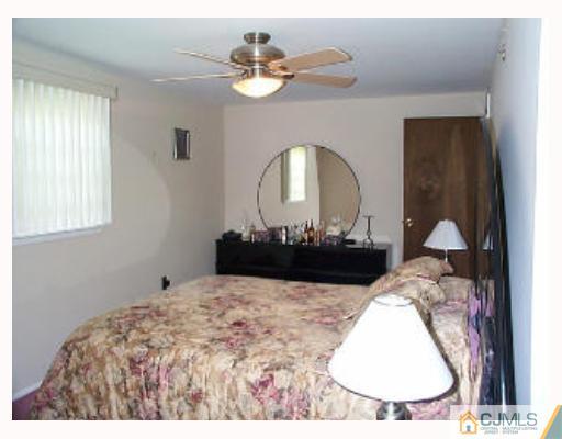 5 Rodney Road East Brunswick, NJ 08816 - Photo 6 of 8 a bedroom with a large bed and a chandelier
