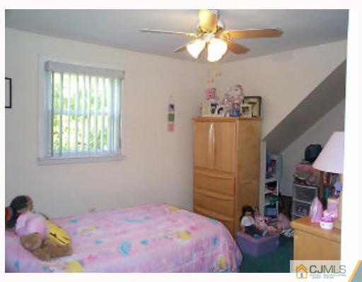 5 Rodney Road East Brunswick, NJ 08816 - Photo 7 of 8 a bedroom with a bed and a chandelier