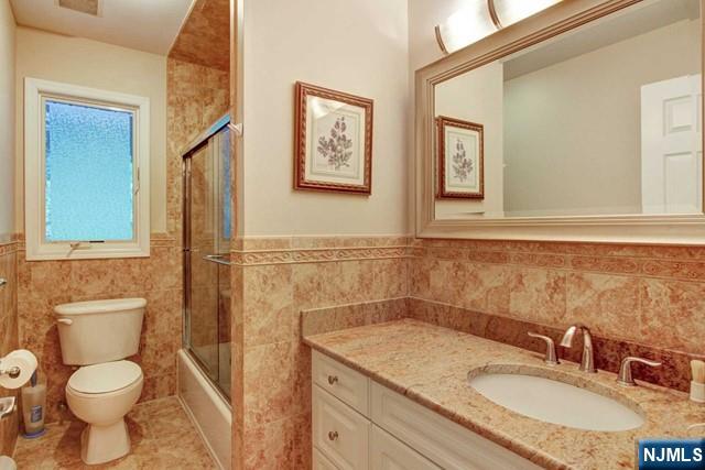 176 Undercliff Avenue Edgewater, NJ 07020 - Photo 17 of 22 a bathroom with a granite countertop toilet sink and mirror