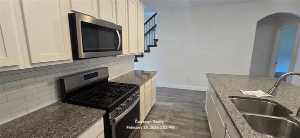 a kitchen with granite countertop a stove and a sink