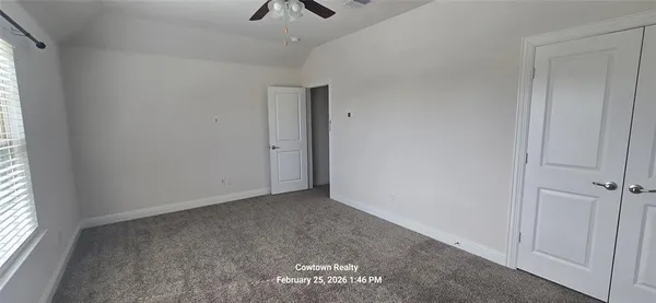 an empty room with windows and fan