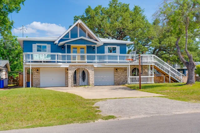 a front view of a house with a garden and trees