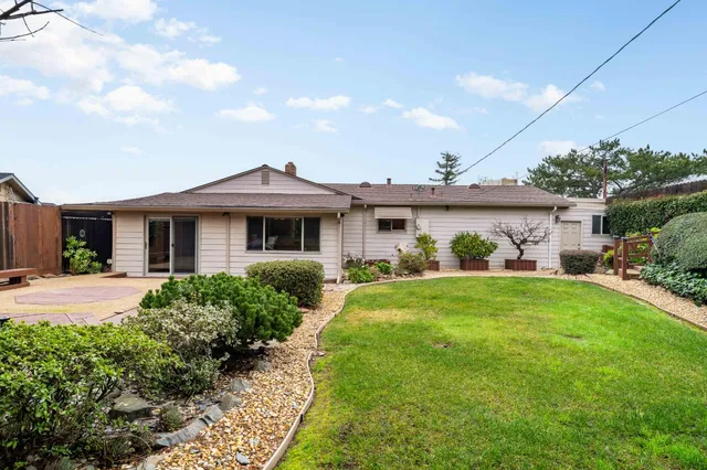 an aerial view of a house with a garden and lake view