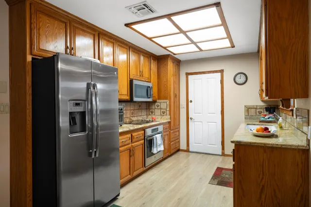 a kitchen with stainless steel appliances granite countertop a sink a stove and cabinets