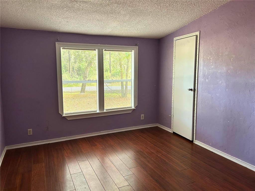 9867 Jerome Drive New Port Richey, FL 34654 - Photo 21 of 30 an empty room with wooden floor and windows