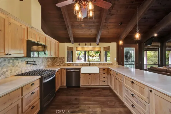 a kitchen with stainless steel appliances a dining table chairs and wooden floor