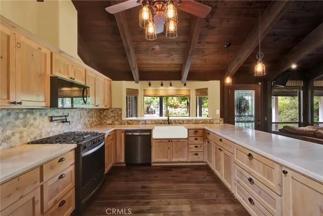 a kitchen with stainless steel appliances a dining table chairs and wooden floor