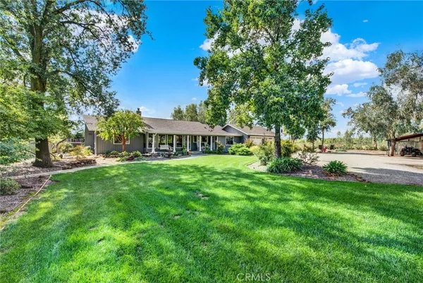 a front view of a house with a yard and tree s