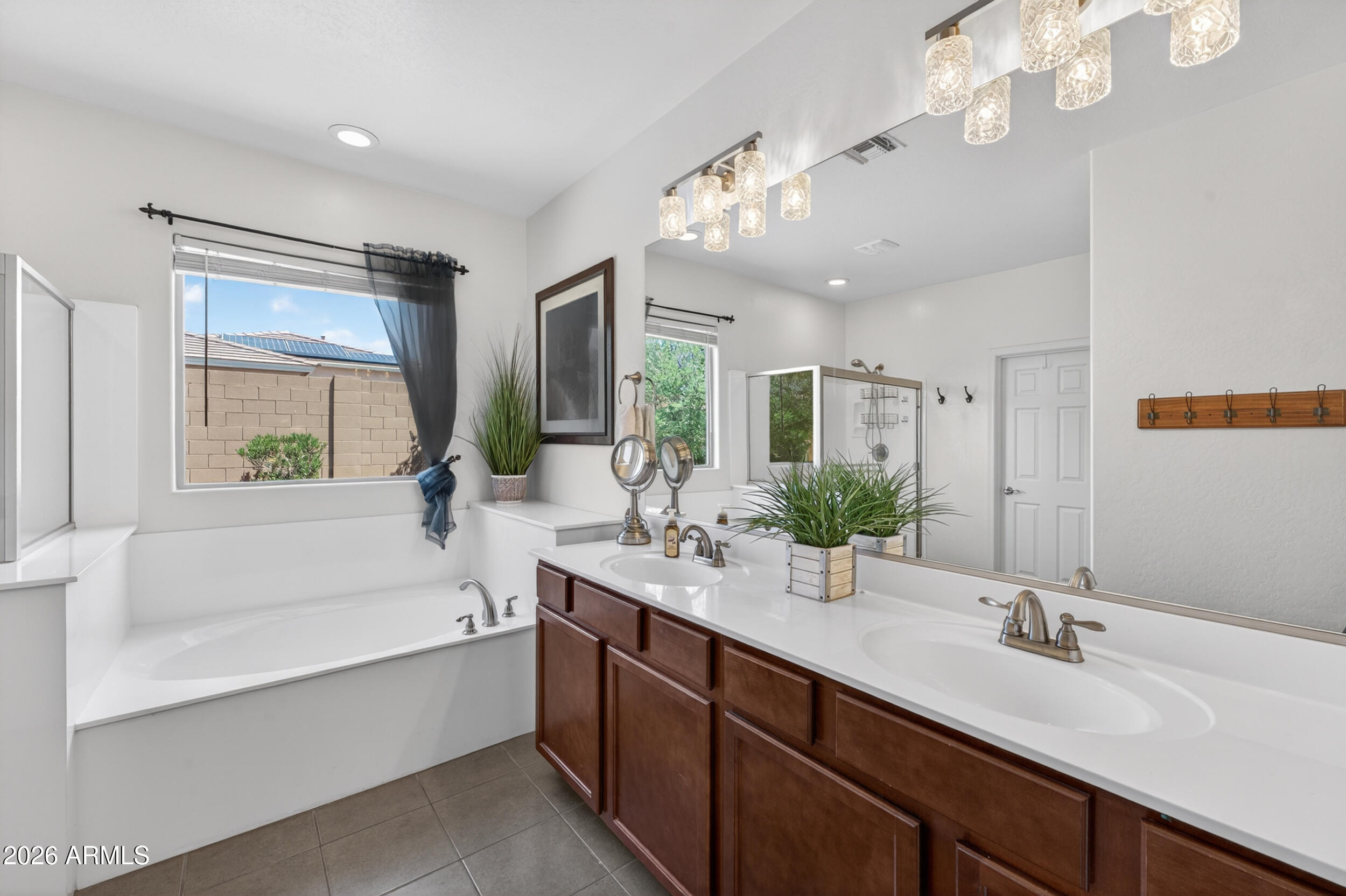 18612 West Mountain View Road Waddell, AZ 85355 - Photo 39 of 71 a bathroom with a tub double sink window and mirror