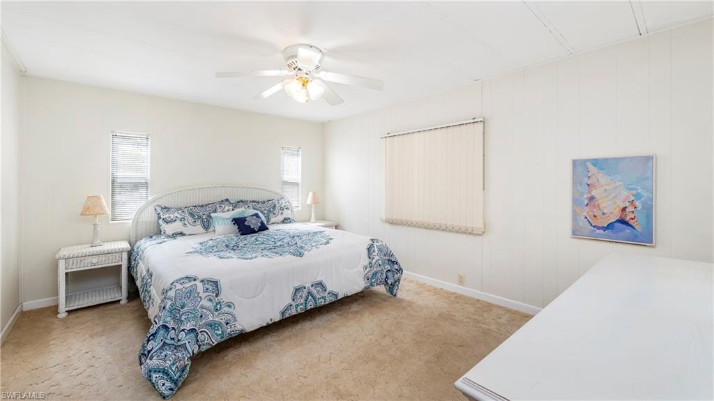 250 Indian Key Lane Naples, FL 34114 - Photo 15 of 33 a bedroom with a large bed and a chandelier