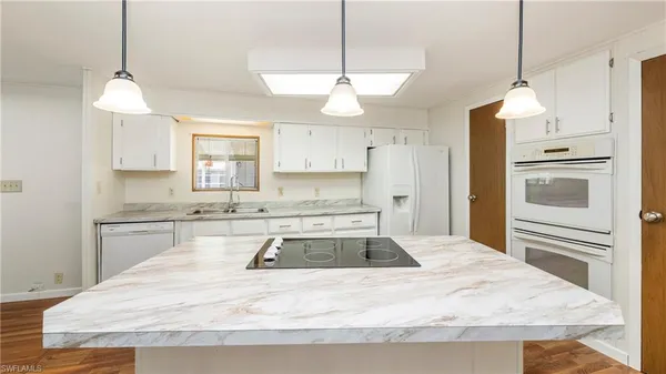 a kitchen with granite countertop a sink stainless steel appliances and cabinets