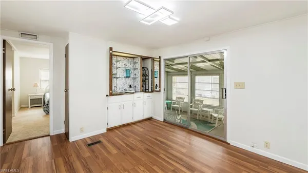 a view of a hallway with wooden floor and a living room