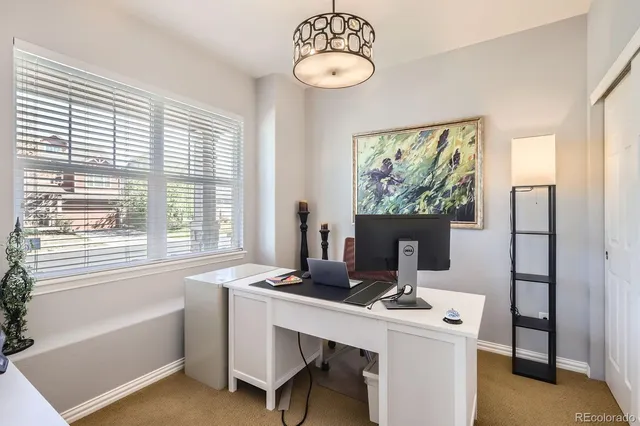 a view of a workspace with furniture and a window