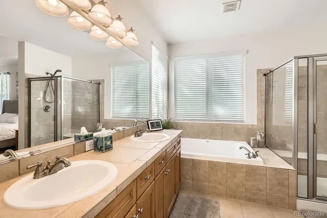 a bathroom with a granite countertop tub sink and mirror