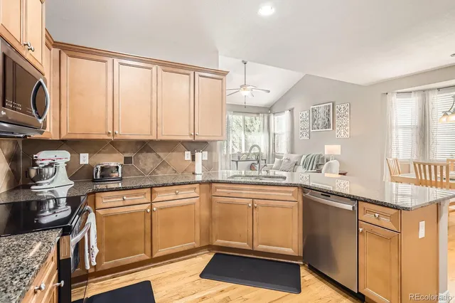 a kitchen with stainless steel appliances granite countertop a stove a sink and a microwave