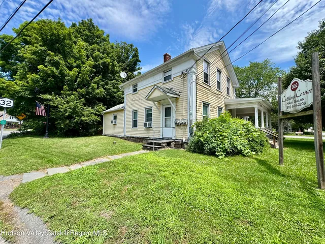 a front view of a house with yard and green space