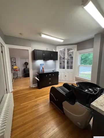 a view of an empty room with wooden floor and a window