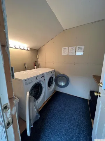 a view of a white house with large windows and a small yard