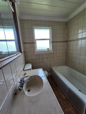 a bathroom with a sink a toilet and bathtub
