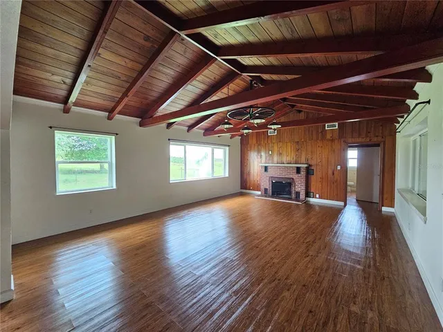 a view of empty room with wooden floor and windows