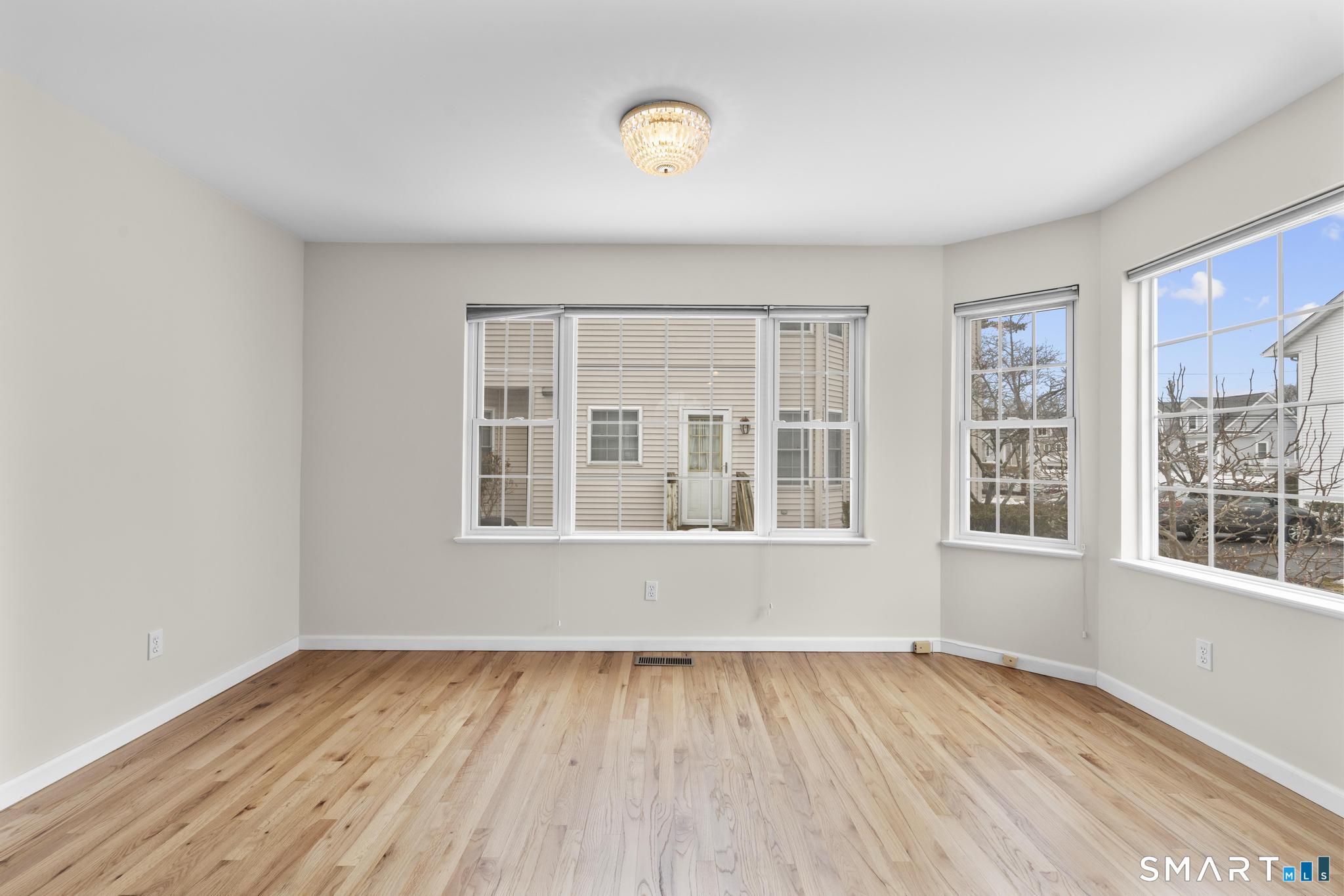 168 Colonial Road, Unit 6 Stamford, CT 06906 - Photo 14 of 41 a view of an empty room with wooden floor and a window