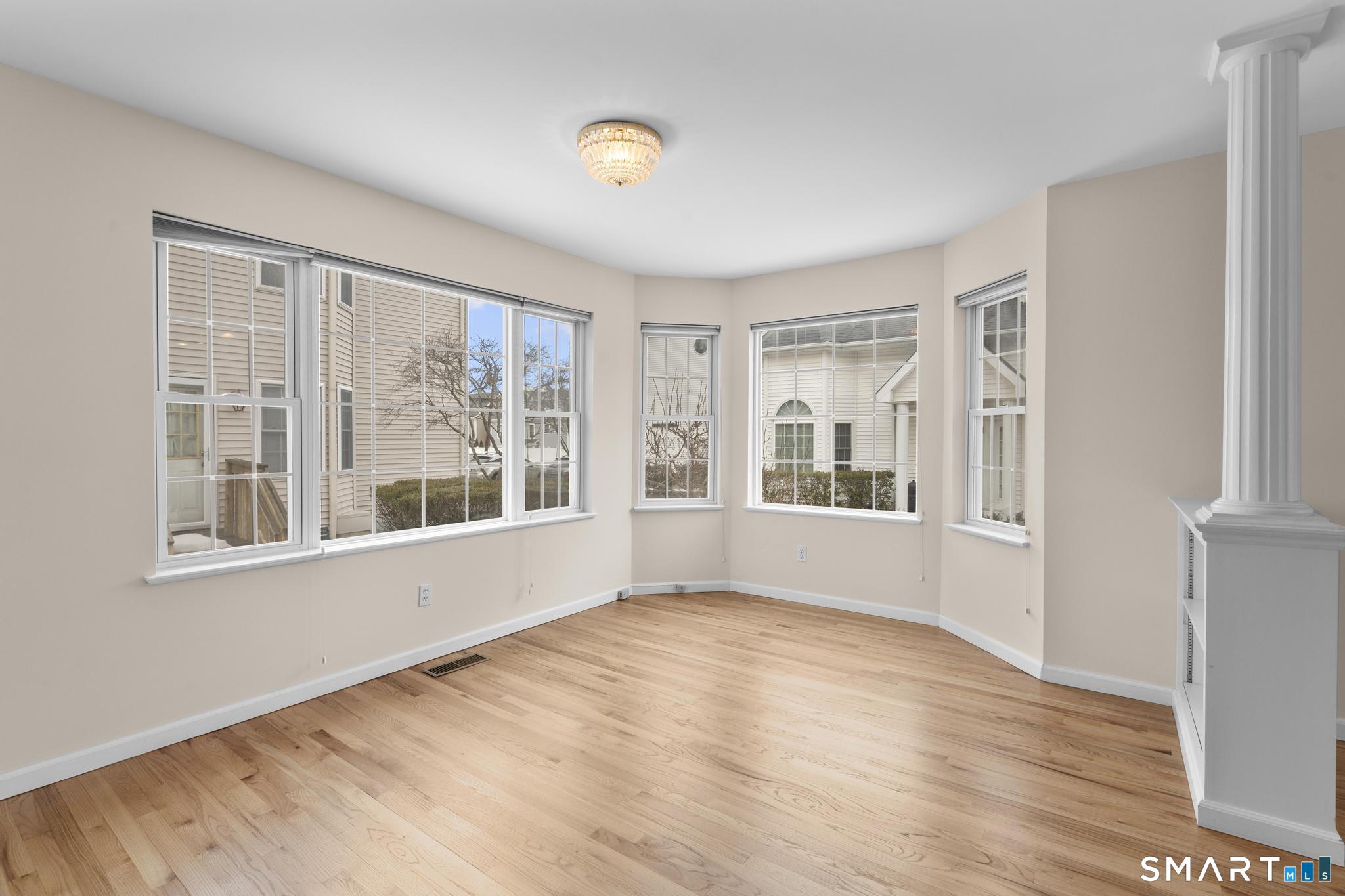 168 Colonial Road, Unit 6 Stamford, CT 06906 - Photo 15 of 41 a view of an empty room with wooden floor and a window