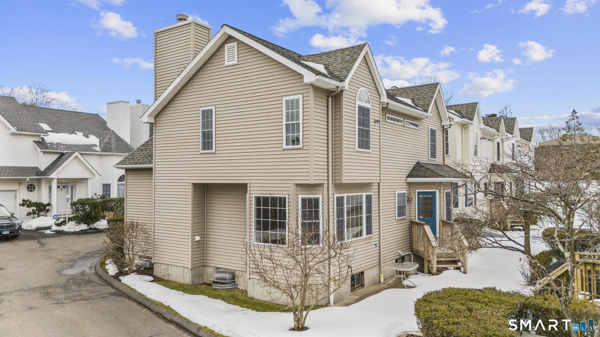 168 Colonial Road, Unit 6 Stamford, CT 06906 - Photo 3 of 41 a view of a white house with large windows next to a road