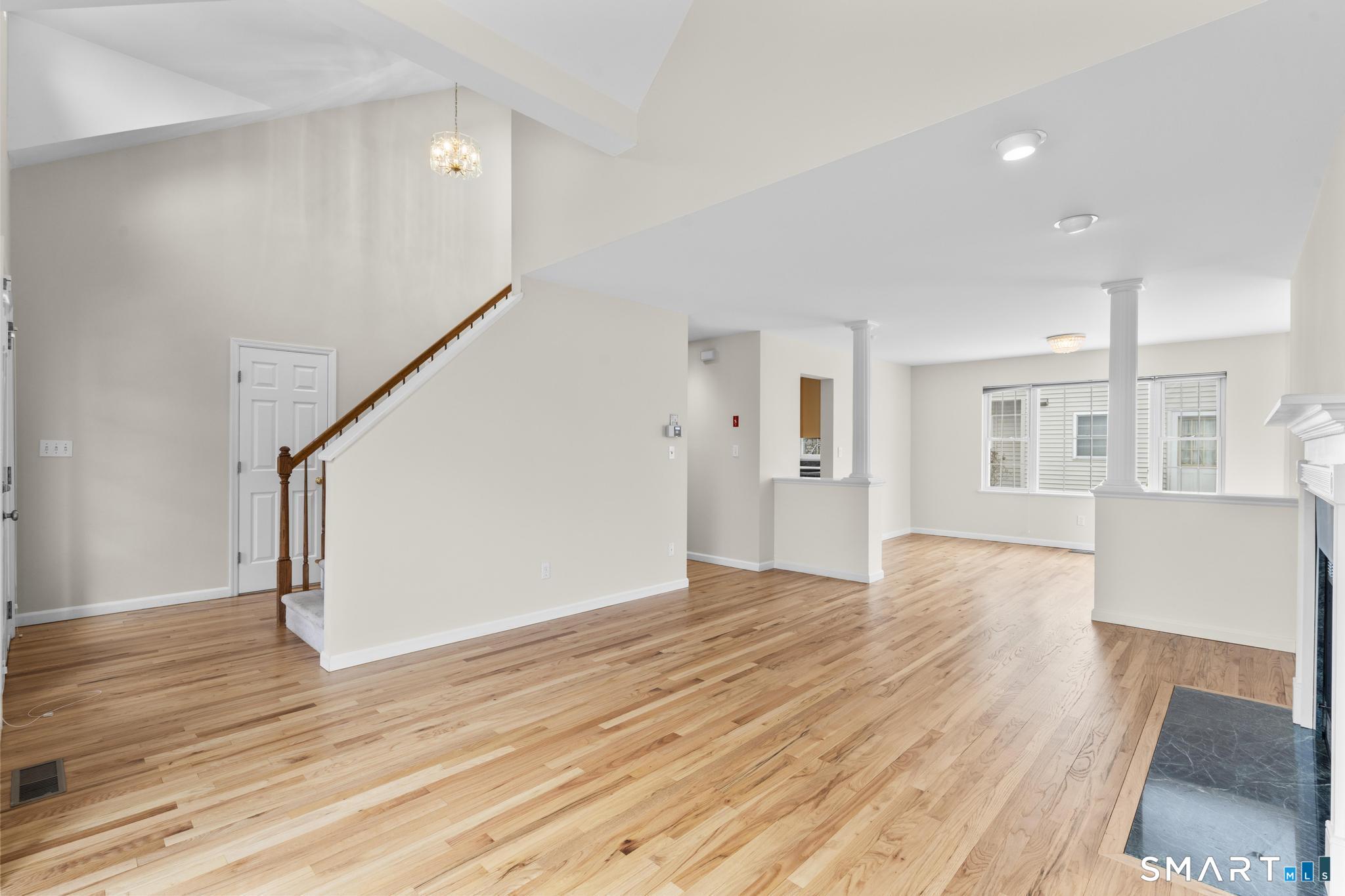 168 Colonial Road, Unit 6 Stamford, CT 06906 - Photo 10 of 41 a view of empty room with wooden floor and kitchen