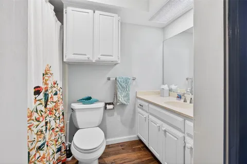 a bathroom with a granite countertop toilet sink and a mirror