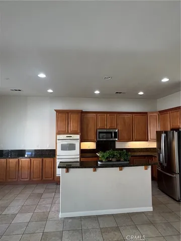 a kitchen with stainless steel appliances granite countertop a refrigerator and a stove