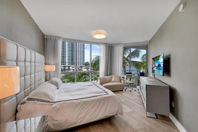 a bedroom with a large bed and a flat tv screen