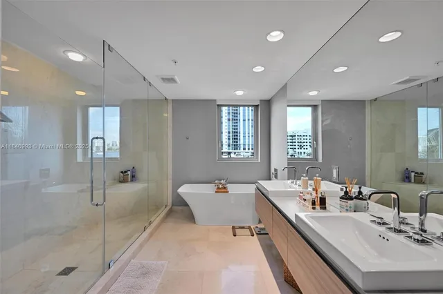 a large bathroom with a double vanity sink a mirror and a bathtub