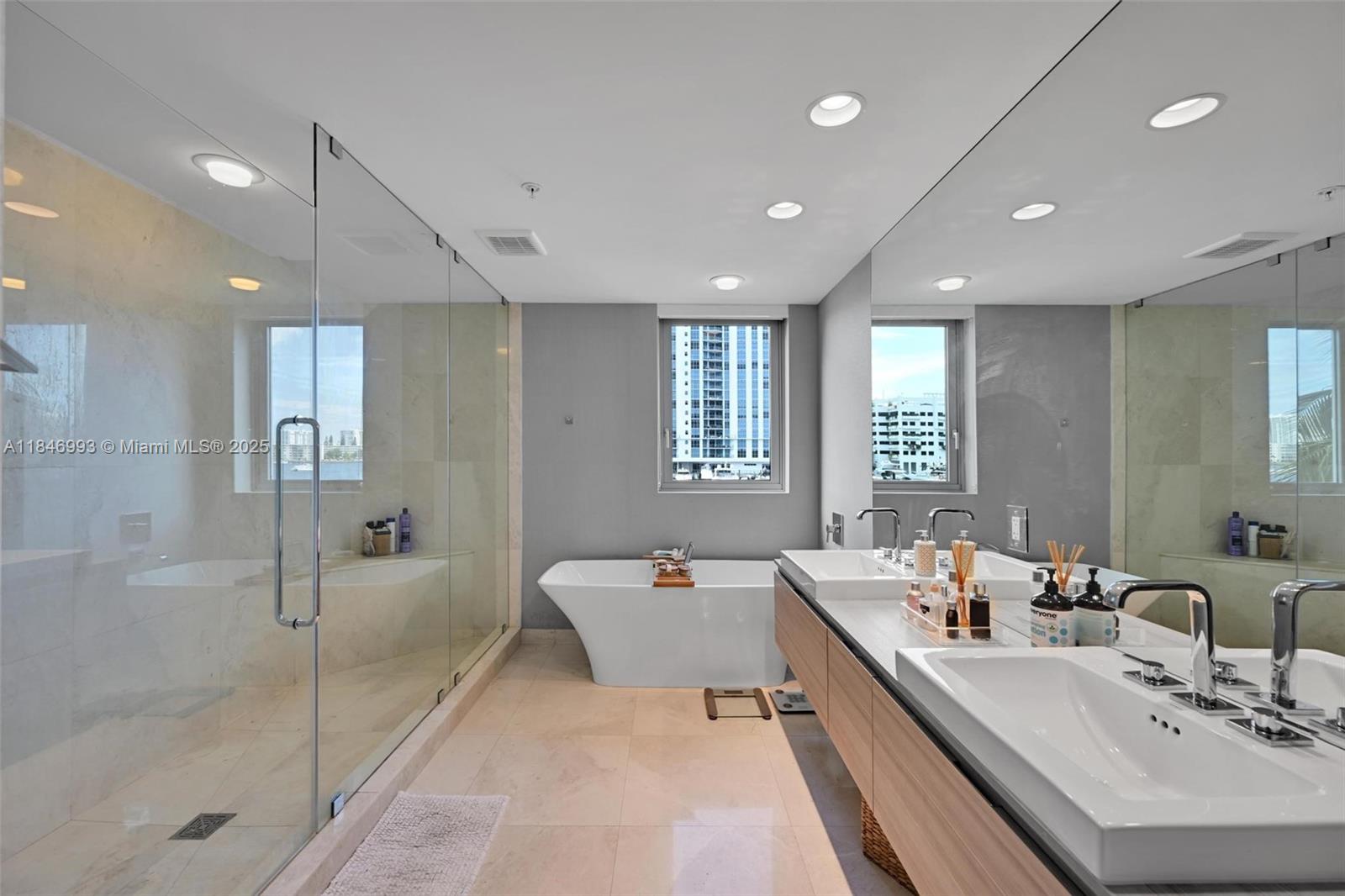 17111 Biscayne Boulevard, Unit 207 North Miami Beach, FL 33160 - Photo 17 of 54 a large bathroom with a double vanity sink a mirror and a bathtub