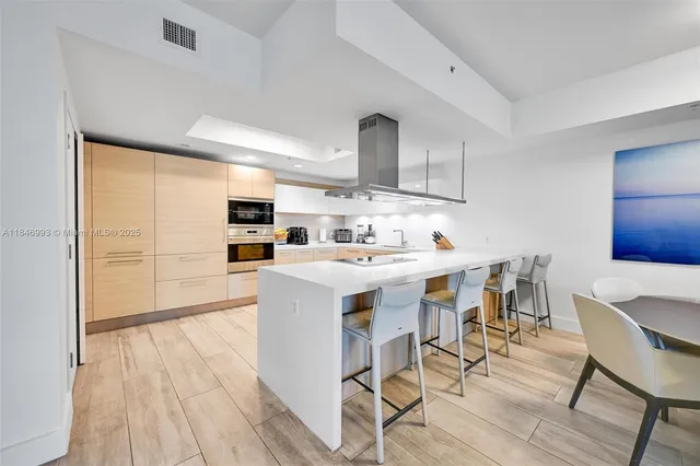 a kitchen with stainless steel appliances kitchen island granite countertop a sink and cabinets