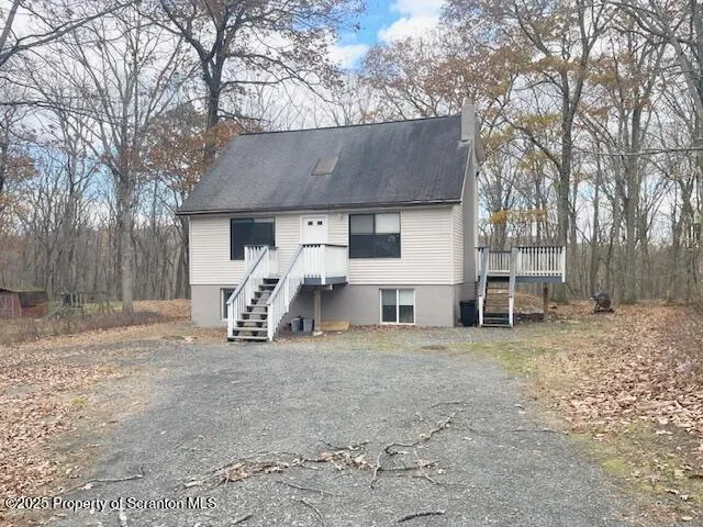 a view of a house with a yard and large tree