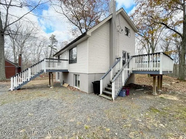 a view of a house with a yard and a wooden deck
