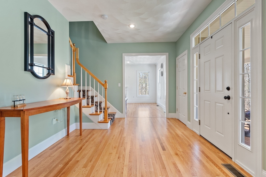 18 Danforth Lane Bolton, MA 01740 - Photo 15 of 29 a hallway with wooden floor and staircase