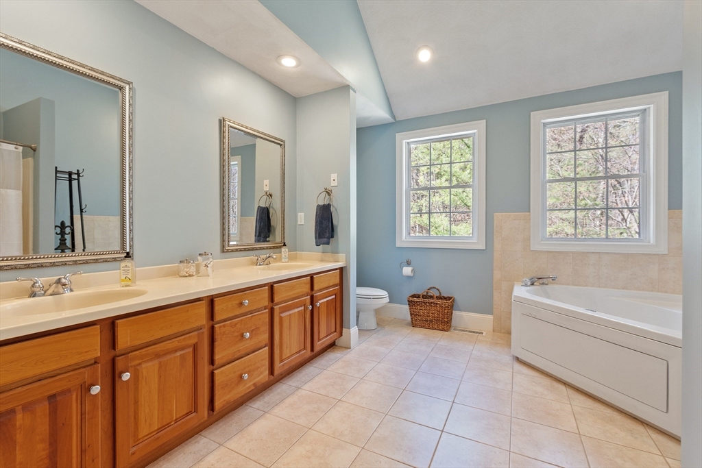 18 Danforth Lane Bolton, MA 01740 - Photo 18 of 29 a spacious en suite bathroom with a granite countertop tub sink and mirror