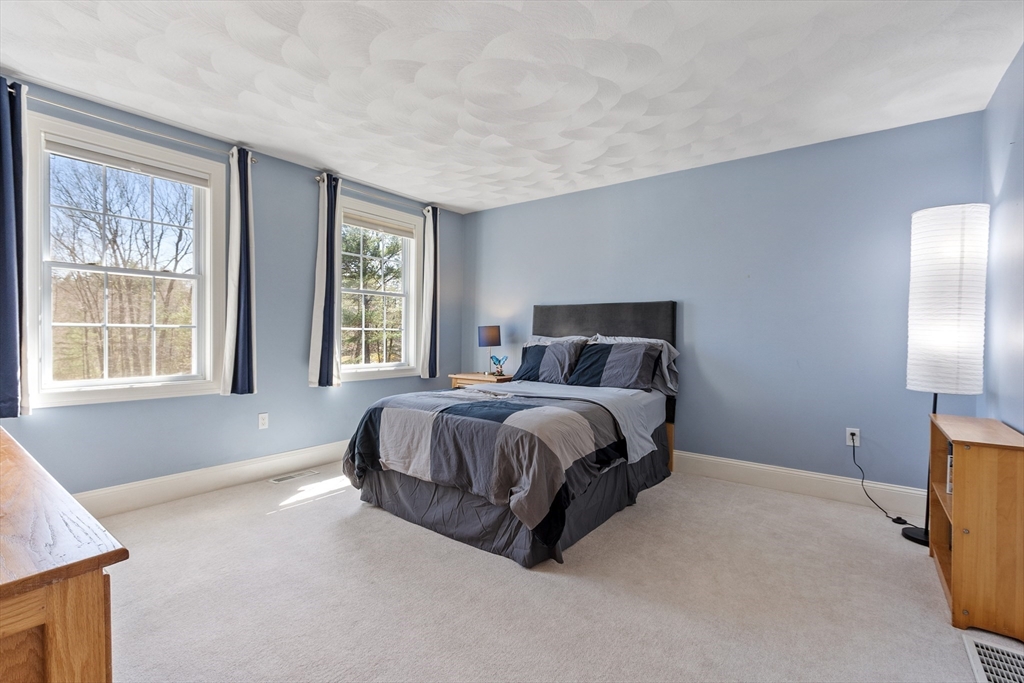18 Danforth Lane Bolton, MA 01740 - Photo 19 of 29 a spacious bedroom with a bed and glass window