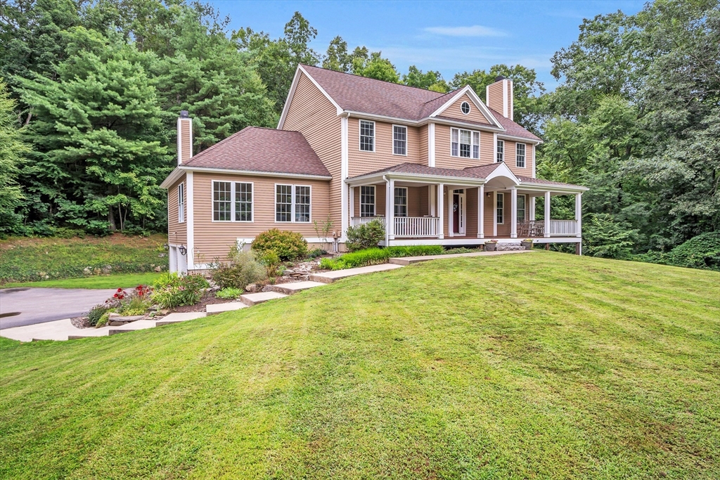 18 Danforth Lane Bolton, MA 01740 - Photo 23 of 29 a front view of a house with a garden and trees
