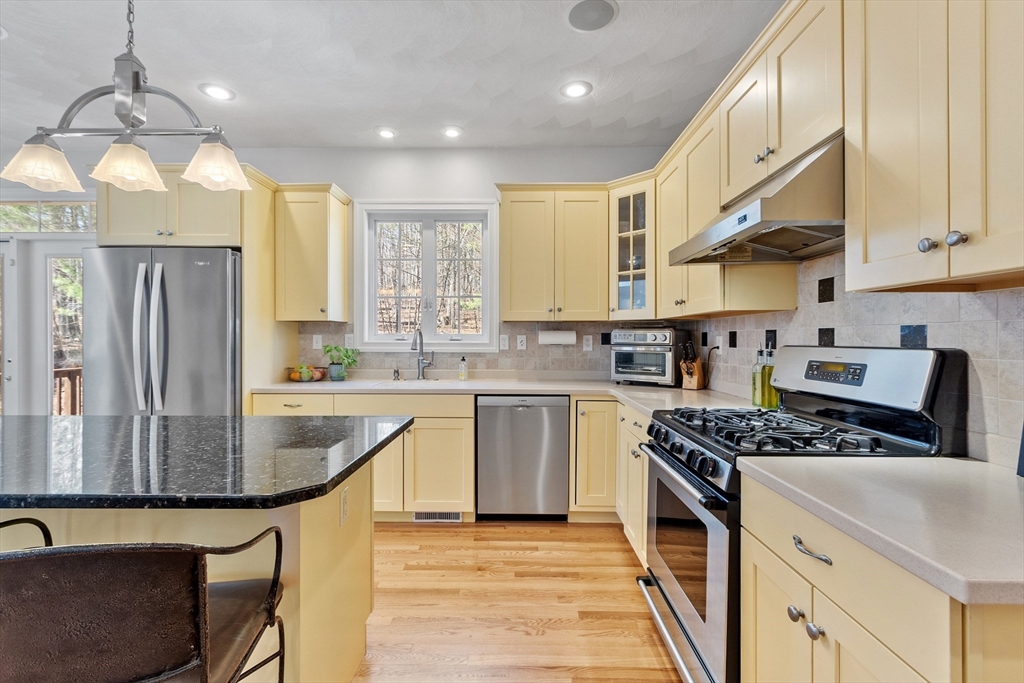 18 Danforth Lane Bolton, MA 01740 - Photo 4 of 29 a kitchen with stainless steel appliances granite countertop a sink stove and refrigerator