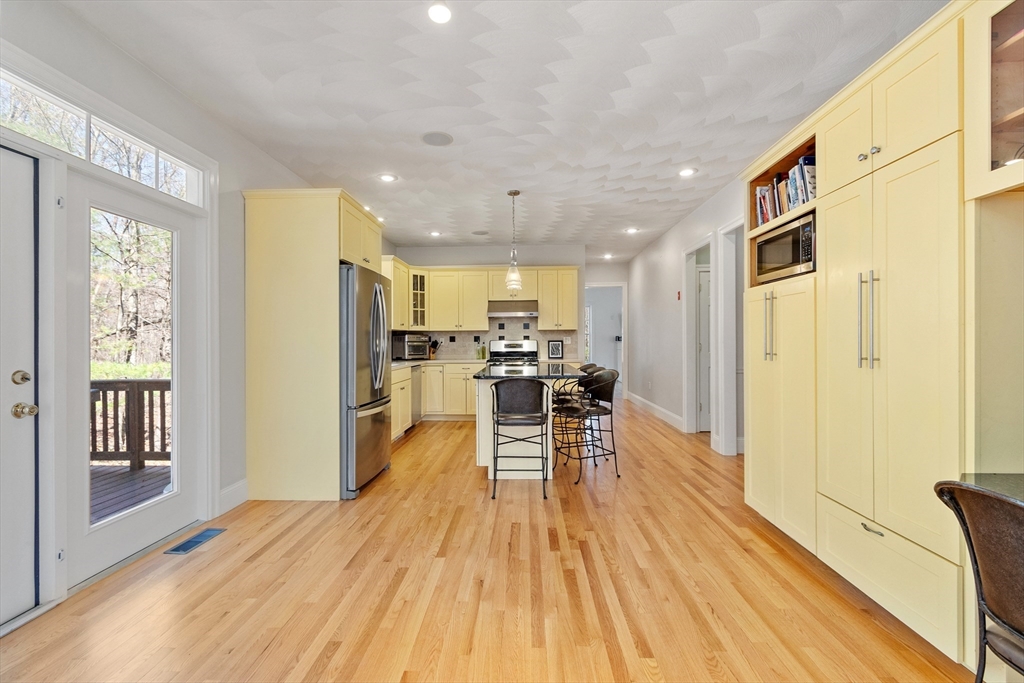 18 Danforth Lane Bolton, MA 01740 - Photo 5 of 29 a dining room with wooden floor and a kitchen